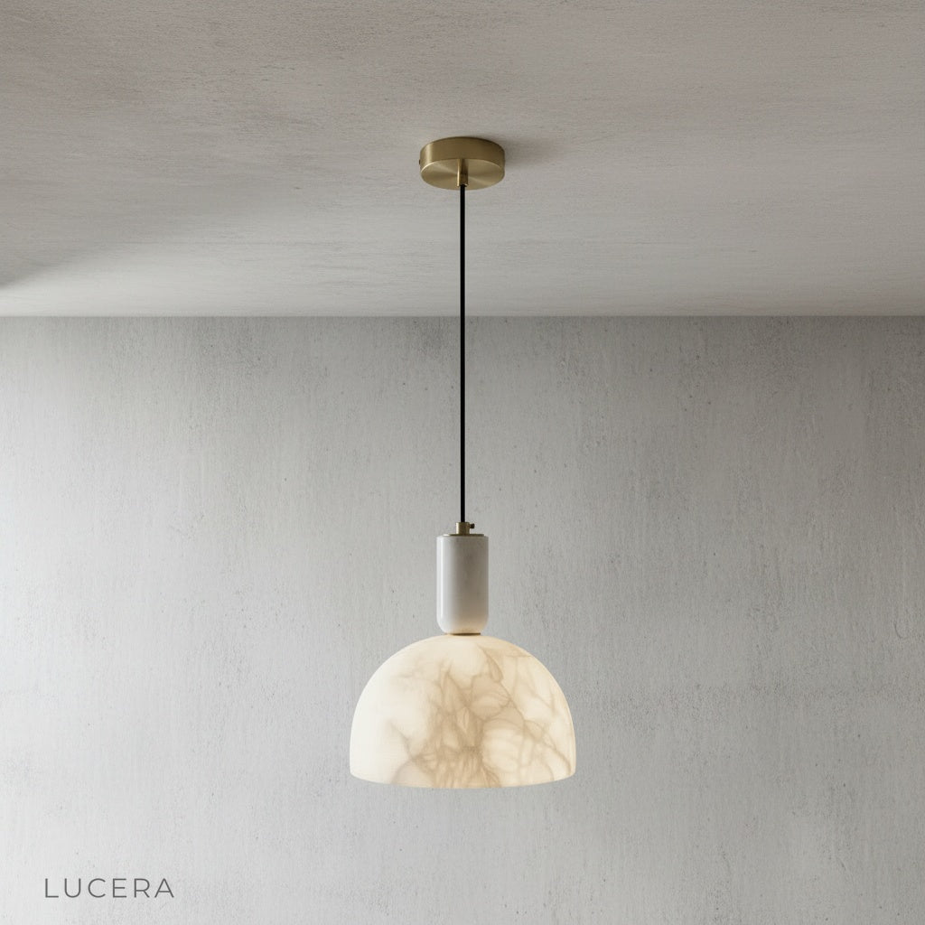 front view of Midas alabaster pendant light hanging from ceiling in minimalist studio setting