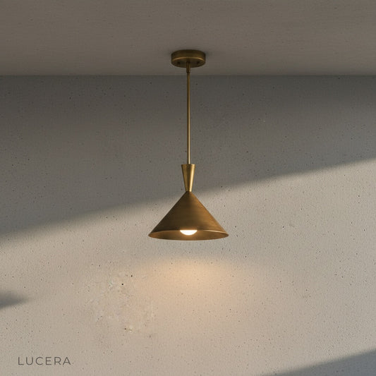 minimalist brass pendant light with open shade shown from a side angle on a neutral backdrop