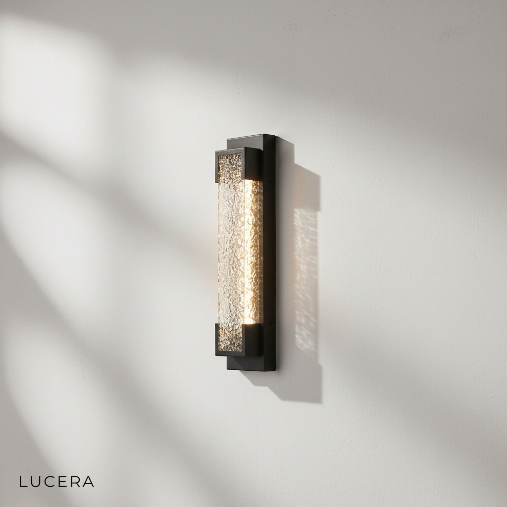 side angle of sleek black outdoor wall sconce mounted on textured stone wall