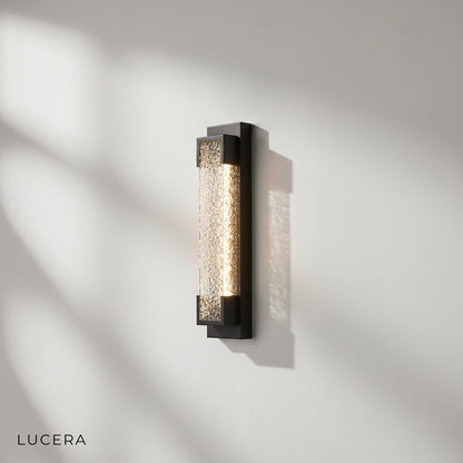 side angle of sleek black outdoor wall sconce mounted on textured stone wall