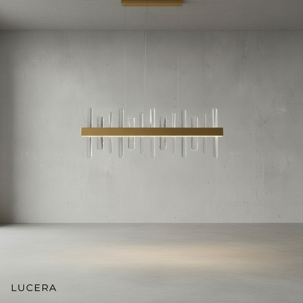 Close-up of Alma chandelier crystal prisms refracting light against gold metal frame