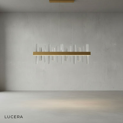 Close-up of Alma chandelier crystal prisms refracting light against gold metal frame