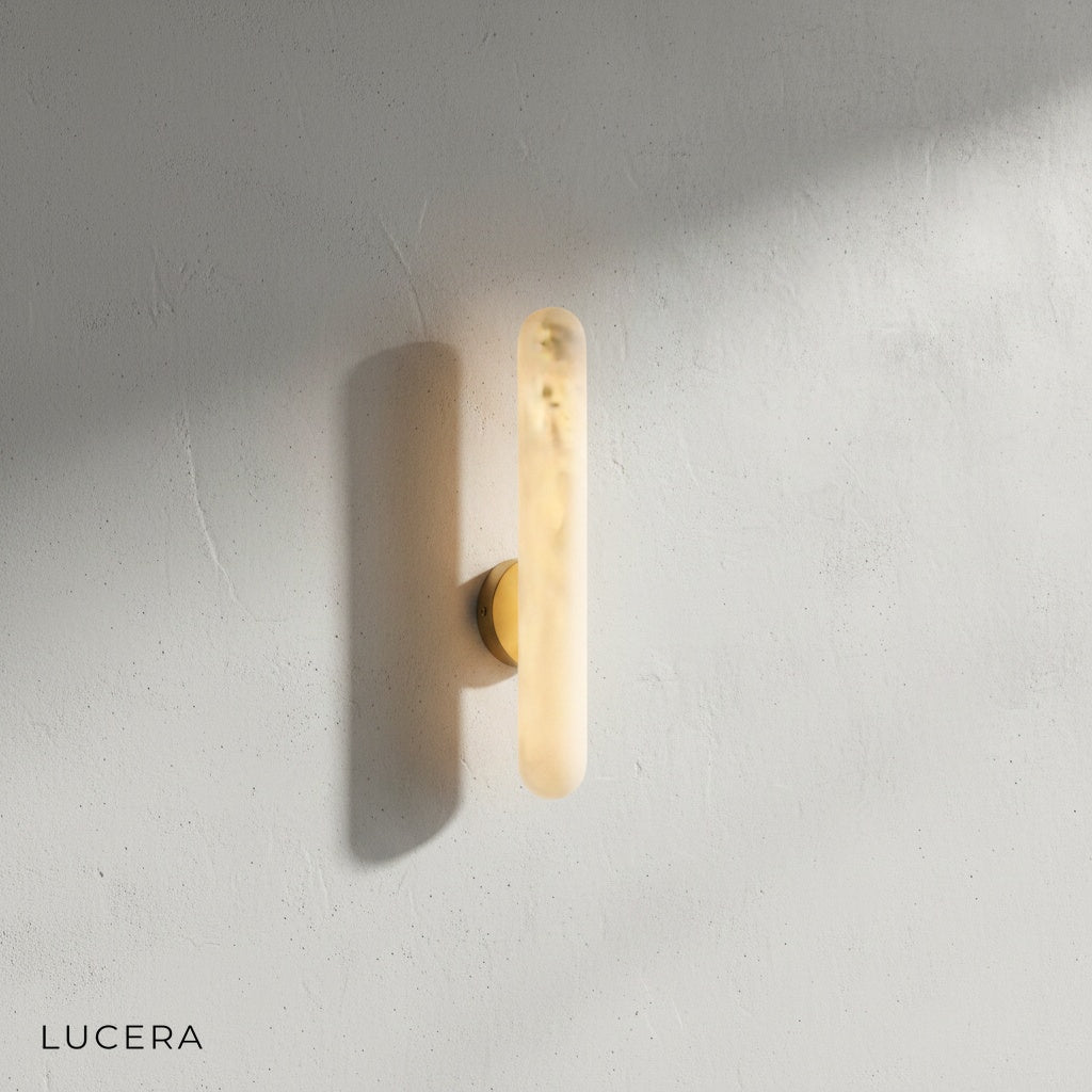 Close-up detail of the genuine alabaster shade and brushed brass fixture of the Cosmo sconce