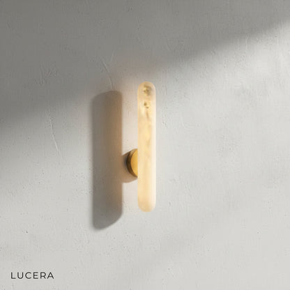 Close-up detail of the genuine alabaster shade and brushed brass fixture of the Cosmo sconce
