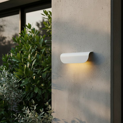 black outdoor sconce mounted on brick wall with soft light spill, daytime exterior