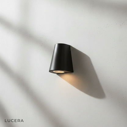 close-up studio view of Avery LED wall lamp showing brushed aluminum frame and warm glow