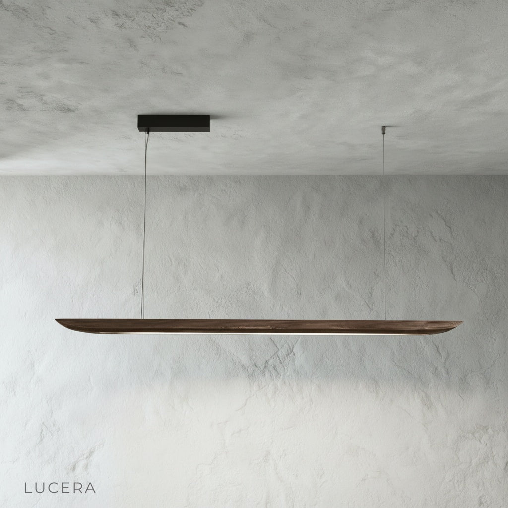 Front view of the Fauvist pendant light with natural wood grain and warm diffused glow in a bright studio setting