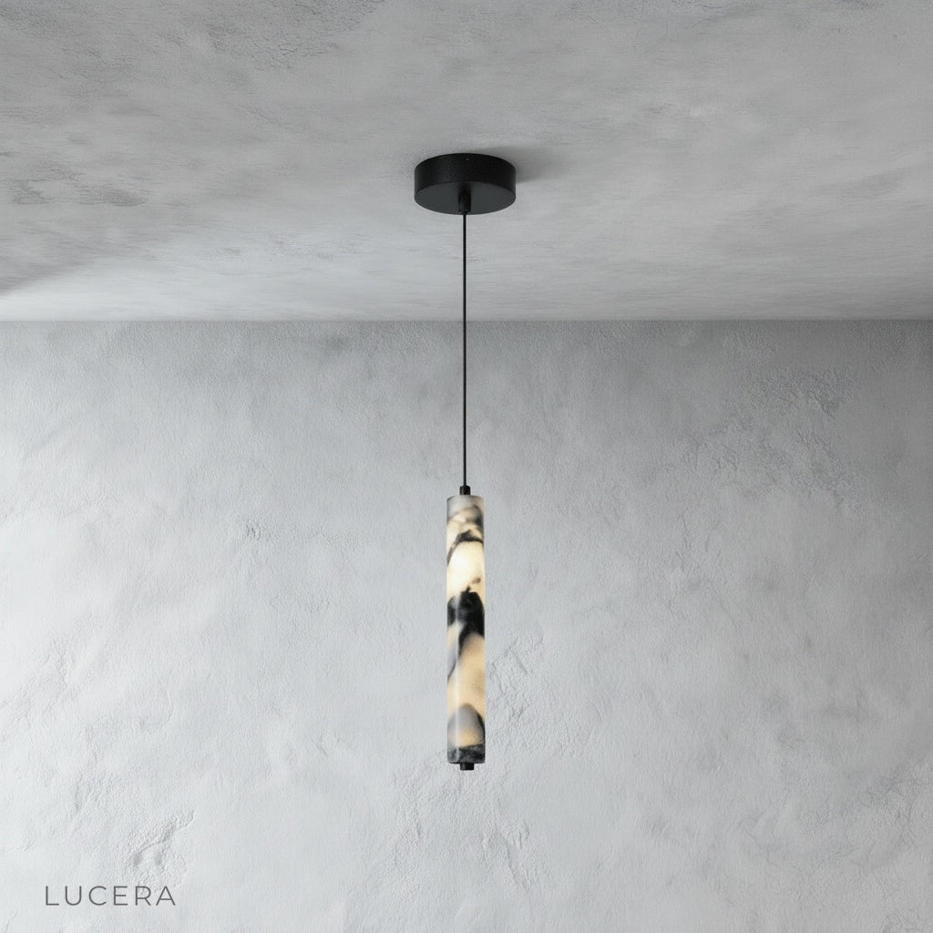 studio shot of a slender cylindrical marble pendant light on a clean white background