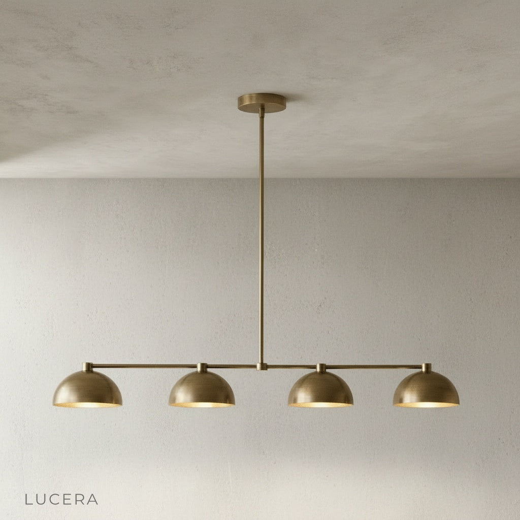 Front view of Lucera Ursule brass dome pendant light hanging from ceiling in studio setting