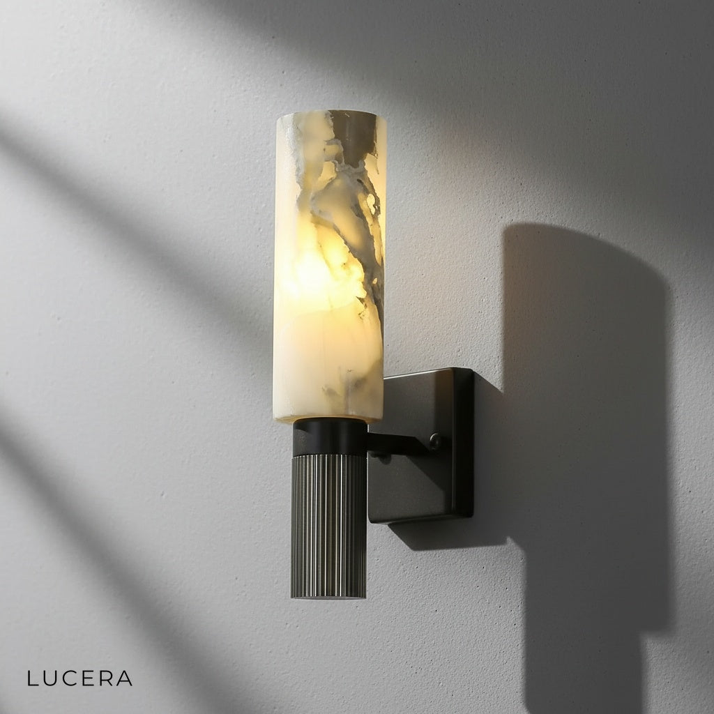 Eris Marble Sconce illuminated in dark moody hallway with soft ambient light on wall