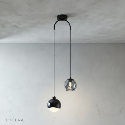 Black Vale pendant light hanging from a ceiling, clean studio background, front view