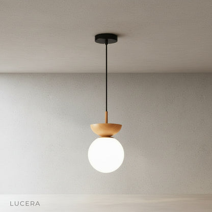 minimalist iron and glass pendant light with warm metal accents on clean studio background