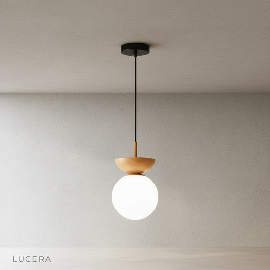 minimalist iron and glass pendant light with warm metal accents on clean studio background