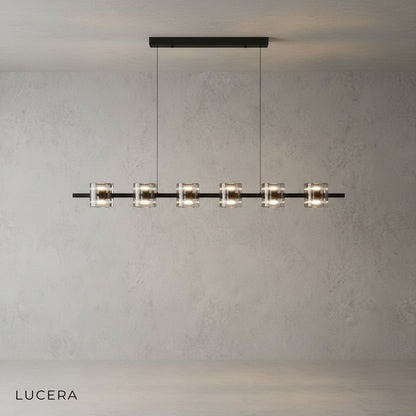 Harlequin chandelier illuminated with warm light against dark wall in entryway