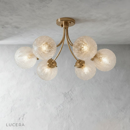 Front view of brass iron ceiling light with patterned glass shades on clean background