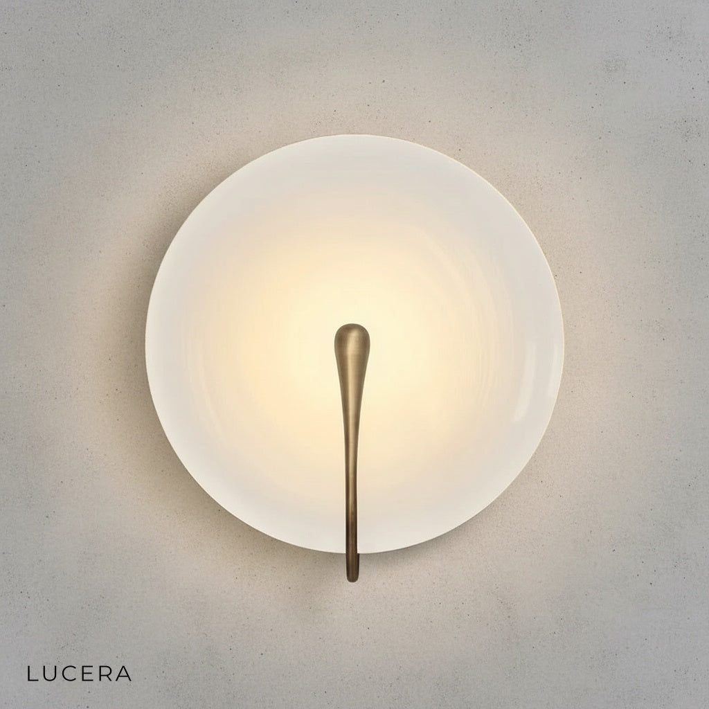 lens-shaped marble sconce casting soft diffused light in bedroom