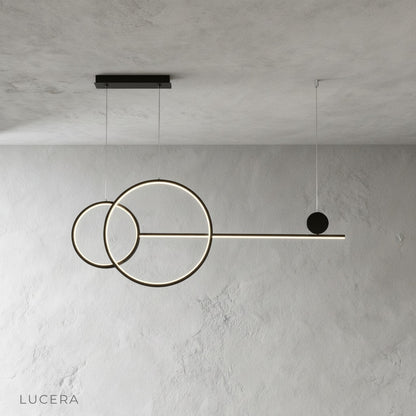 Black Brumal pendant light hanging from ceiling in minimalist studio setting