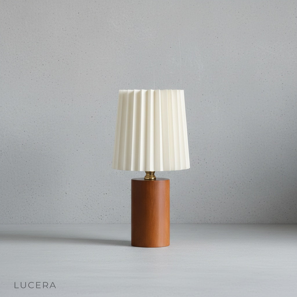 Minimalist studio view of Pandora Table Lamp at three-quarter angle showing brass details and wood grain texture