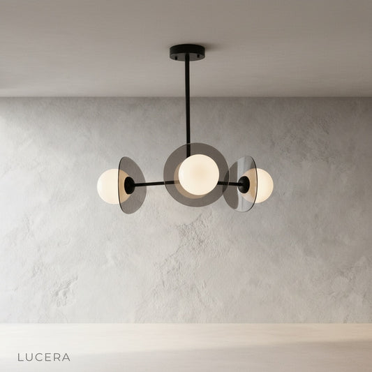front view of Norma chandelier showing reflective copper discs and clear glass globes in clean studio setting
