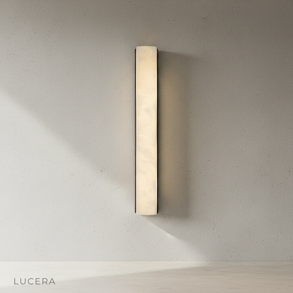Minimalist brass wall sconce with brown finish displayed alone in bright studio setting