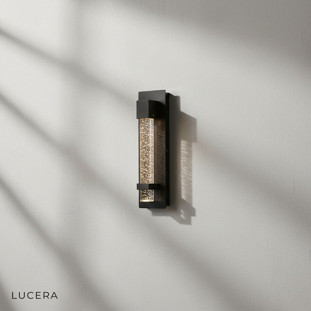 Hemera Outdoor Sconce illuminating a brick exterior entryway at night