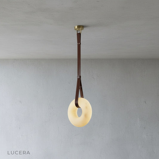 studio shot of Butte Alabaster pendant light with stacked alabaster rings and leather straps