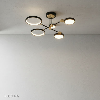 Minimalist studio view of black and gold yin-yang ceiling light against clean white background