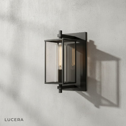 Ariel wall lamp with warm light illuminating a dark textured wall in an indoor hallway