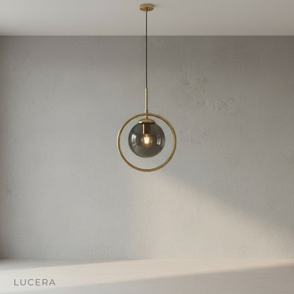 Caelus pendant light front view against neutral gray backdrop highlighting clear glass and gold finish