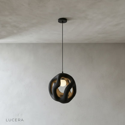 front view of Lucera flame pendant light hanging from ceiling in minimalist studio setting