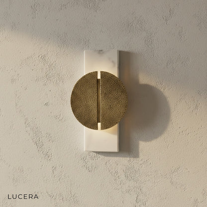 close-up of natural marble veining and brushed copper finish on wall lamp
