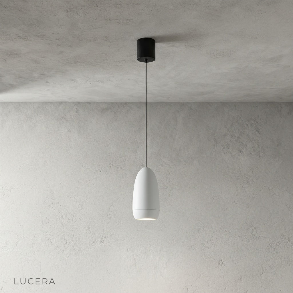minimalist aluminum capsule pendant light hanging at varying heights in studio