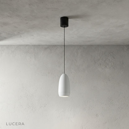 minimalist aluminum capsule pendant light hanging at varying heights in studio