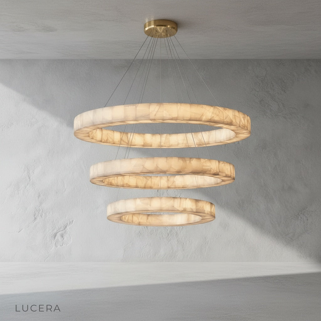 Nighttime lifestyle image of the chandelier illuminating a minimalist lounge with dark green walls