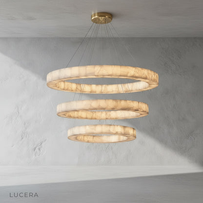 Nighttime lifestyle image of the chandelier illuminating a minimalist lounge with dark green walls
