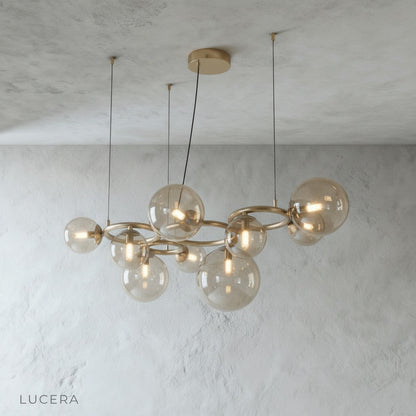 Grenache chandelier with warm glow against dark wall in lounge