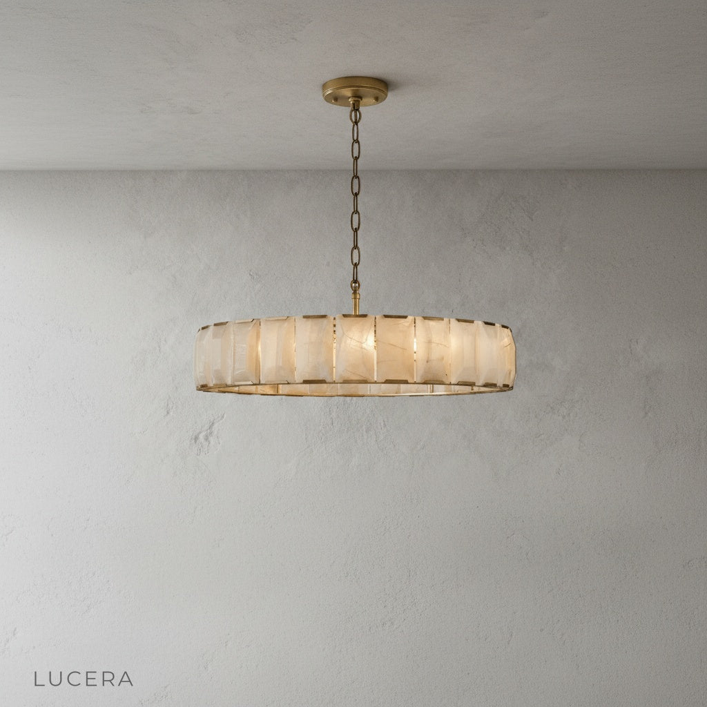 Vivid Round Alabaster Chandelier hanging over a kitchen island with bar stools in background