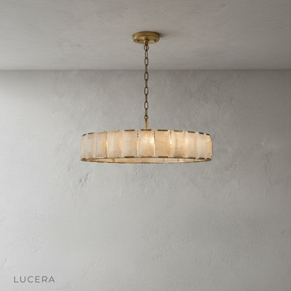 Vivid Round Alabaster Chandelier hanging over a kitchen island with bar stools in background