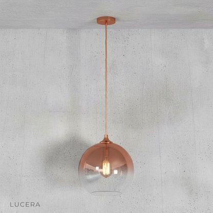 Green gold pendant light in an open-plan space with neutral tones and natural light
