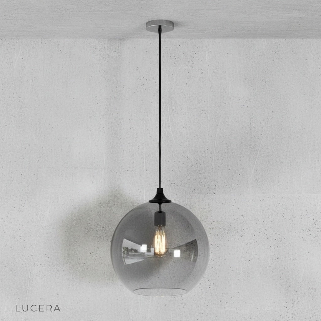 Green gold ombre pendant light hanging low over a rustic wooden table in a loft