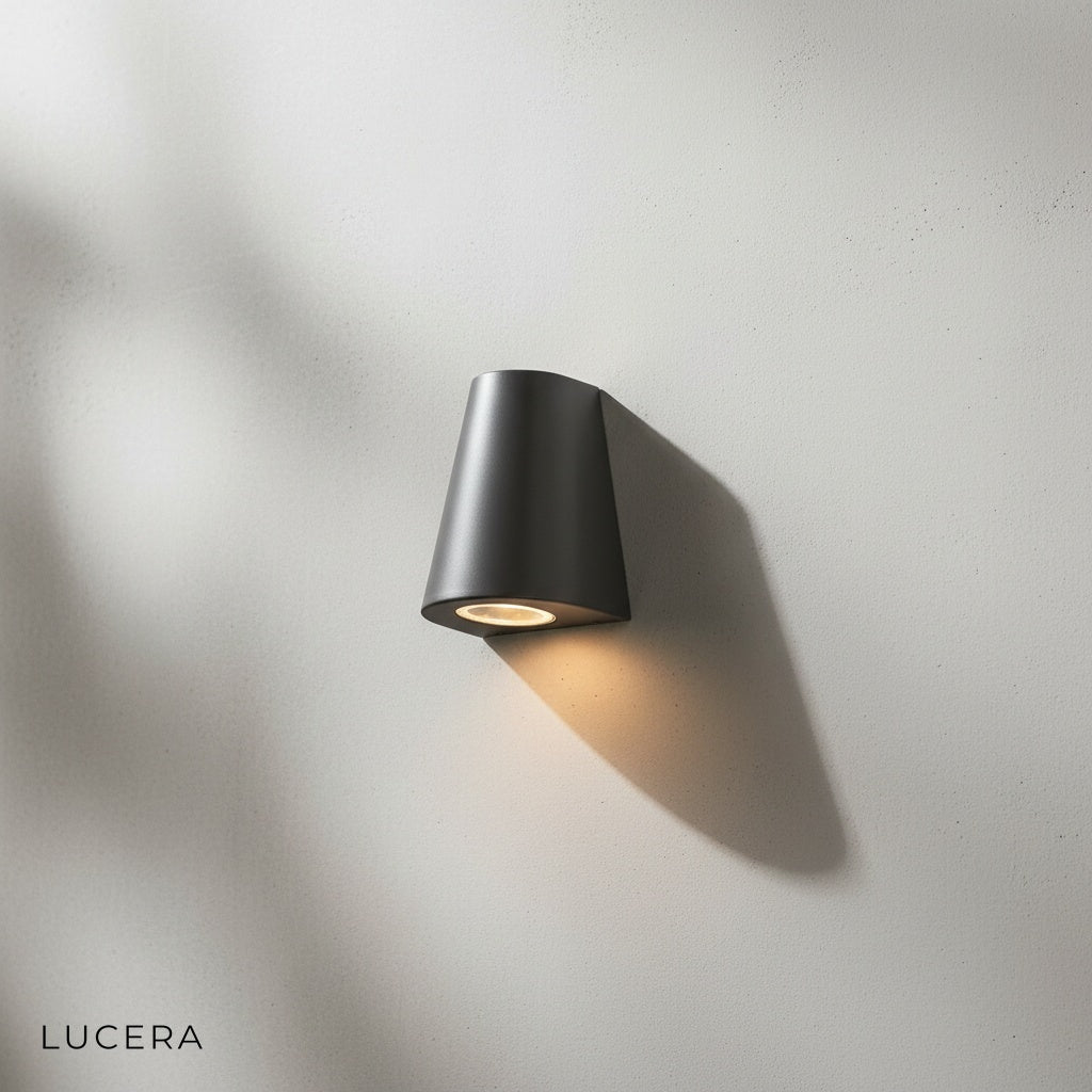 Avery outdoor wall lamp side angle on a neutral concrete wall in daylight