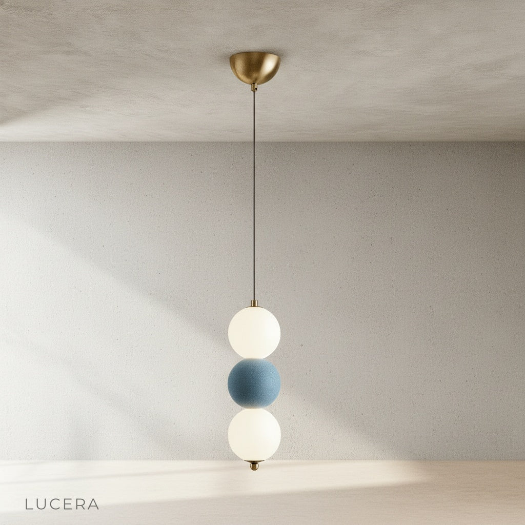 Close-up detail of Sogno pendant light showing textured metal spheres and warm frosted glass diffuser