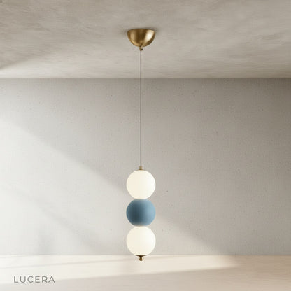 Close-up detail of Sogno pendant light showing textured metal spheres and warm frosted glass diffuser