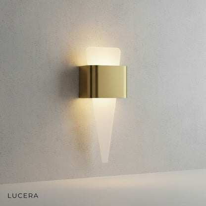 Passo Shark Tooth sconce mounted on dark wood paneling casting a soft ambient glow
