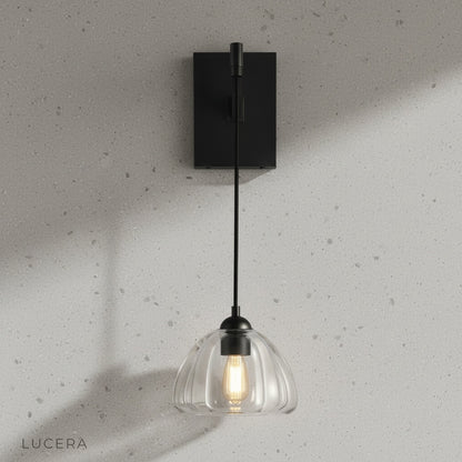 Close-up of Zuleika Wall Lamp clear glass shade with exposed vintage bulb