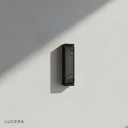 contemporary exterior lamp casting warm light beside a wooden entry door