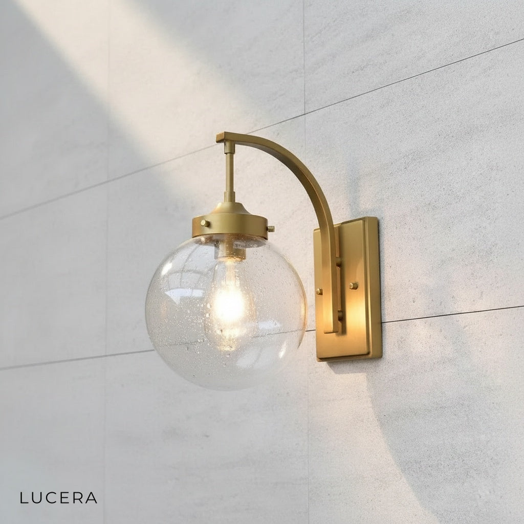 Close-up of Nyx wall light stainless steel frame and clear glass globe texture