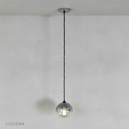 Front view of Lucera green gold ombre glass pendant light in minimalist studio setting