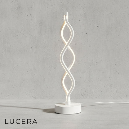 Tristezza lamp in natural light mode, spiral silhouette against soft beige wall
