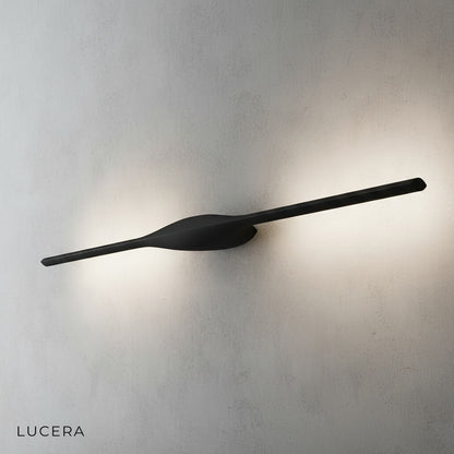 Elan wall lamp in brushed aluminum finish mounted on neutral wall in hallway